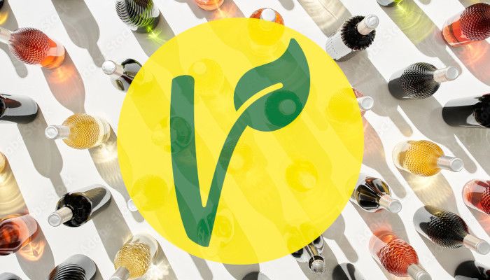 Icono de vino vegano formado por una letra V de color verde sobre un círculo amarillo, y un fondo con botellas de vino.