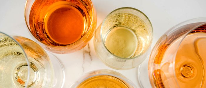 Bicchieri con vino orange in diverse tonalità: giallo dorato, mandarino e ambra