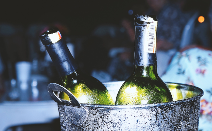 Two bottles of wine in an ice bucket. Foto by Andrés Gómez from Unsplash.