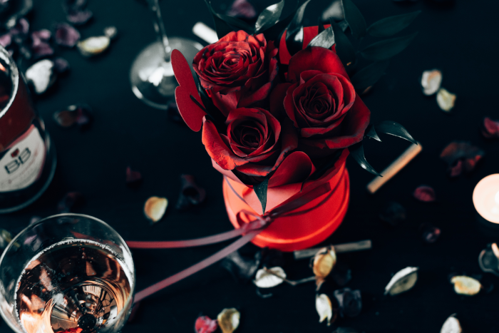 Red roses near clear wine glasses. Foto by Erik G from Pexels.