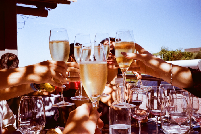 A group of people toasting with glasses of wine. Photo by Micaela Peduzi from Unsplash.